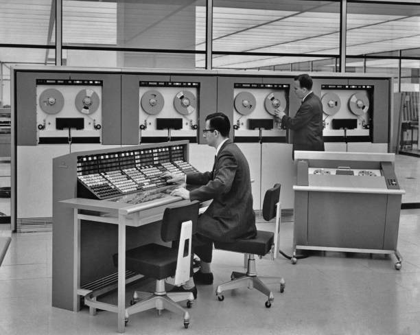 Two men operating a mainframe computer circa 1960 Historic 1960s Old Photo